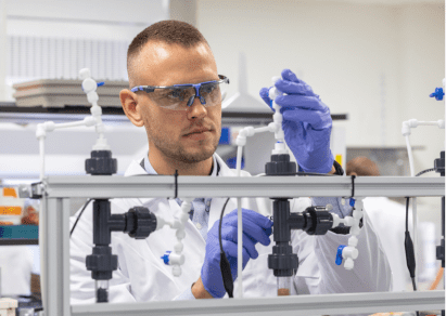Puraffinity CEO Henrik Hagemann in lab wearing lab coat, gloves and protective eyewear,