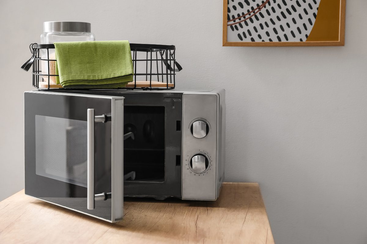 Microwave oven in minimalist domestic setting, with door ajar