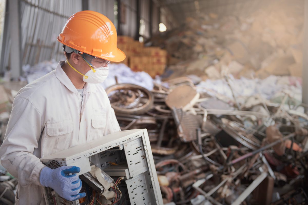 Electronic waste being carried by a worker at a recycling facility