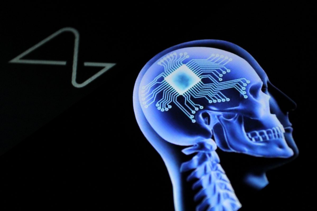 Neuralink logo, which includes illustration comprising conceptual side profile view of human skull with implanted chip and associated structures