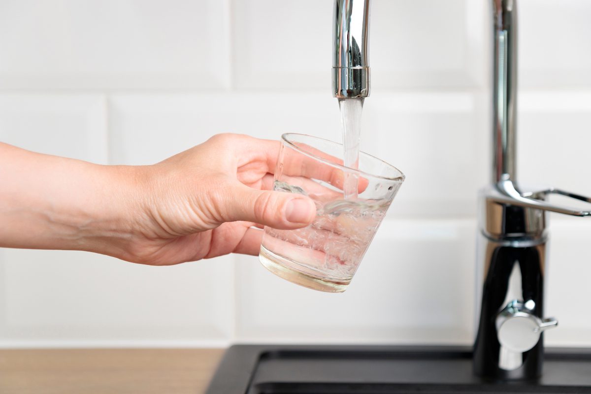 Glass of water being held under a running tap