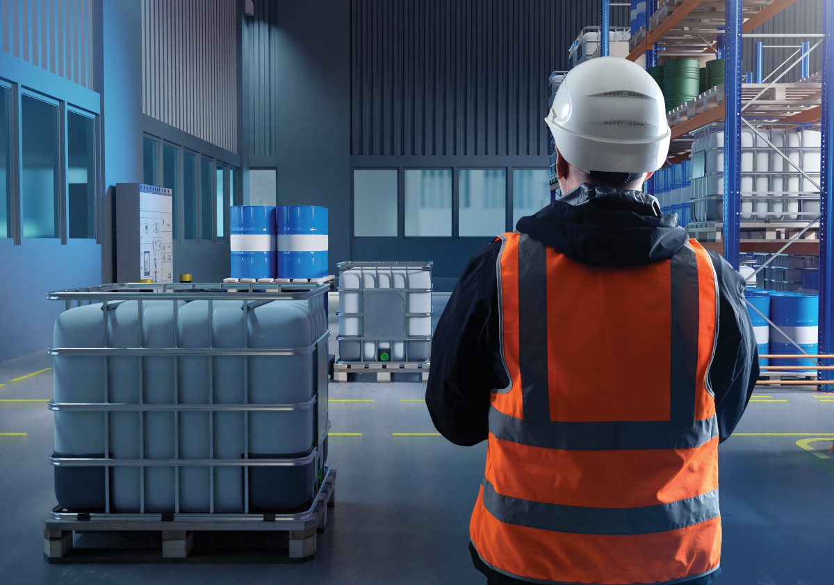 Illustration showing industrial interior with storage containers and worker in luminous vest and hard hat with back to the viewer