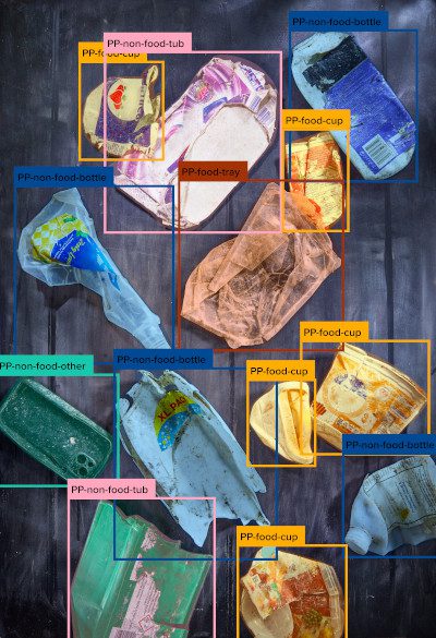 Multiple plastic waste items are identified and framed by yellow bounding boxes, suggesting an AI-driven sorting mechanism