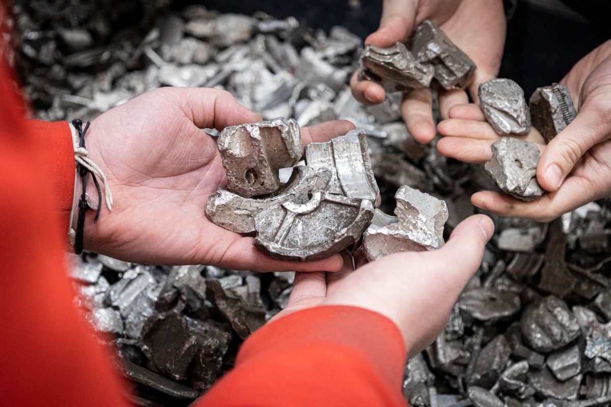 Human hands holding fragments of metal waste