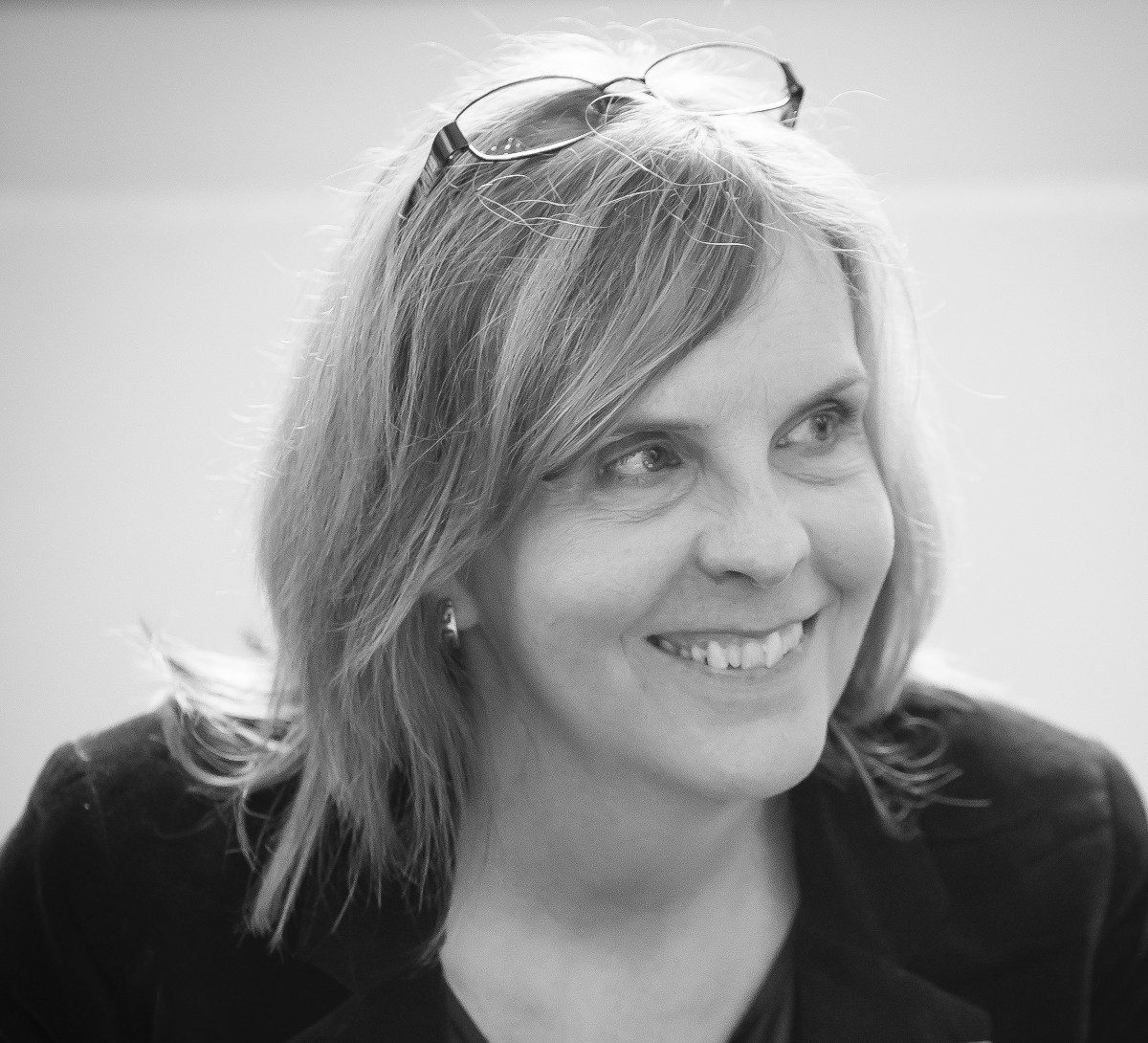 A woman's face, smiling, as she looks off to the side