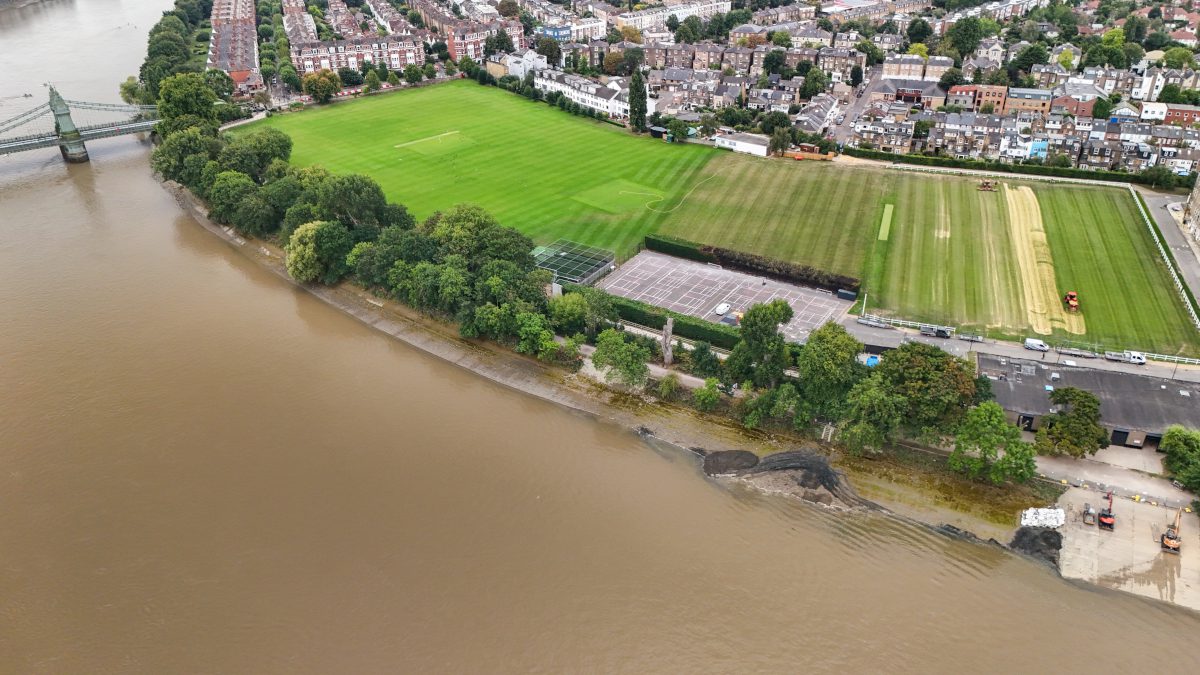 An aerial view showing an area of the Thames River and its shoreline with adjacent fields and urban landscape also visible