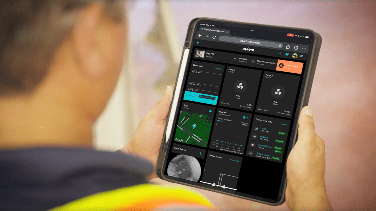 The view of a tablet screen, the image taken from just behind the user's shoulder, showing a dark screen with square icons, seemingly the control panel view for some kind of system
