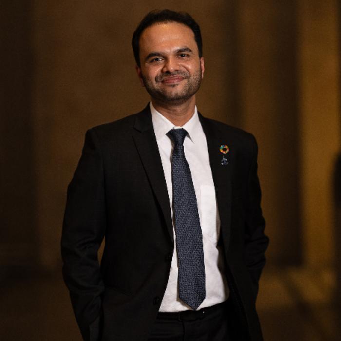 Man in business attire smiles at the camera