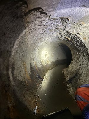Interior of drainage pipe, the grey lumpy surface is dirty and scaly