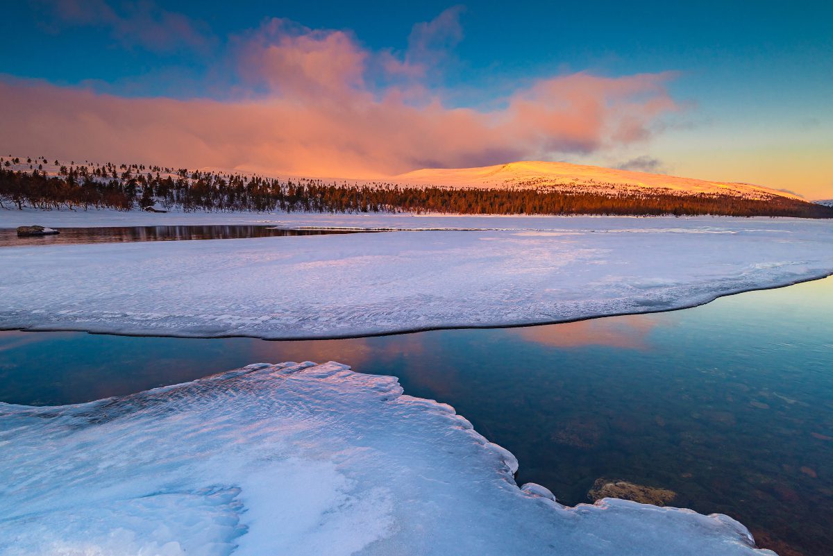 Ice on surface of a lake, with sunset in the background