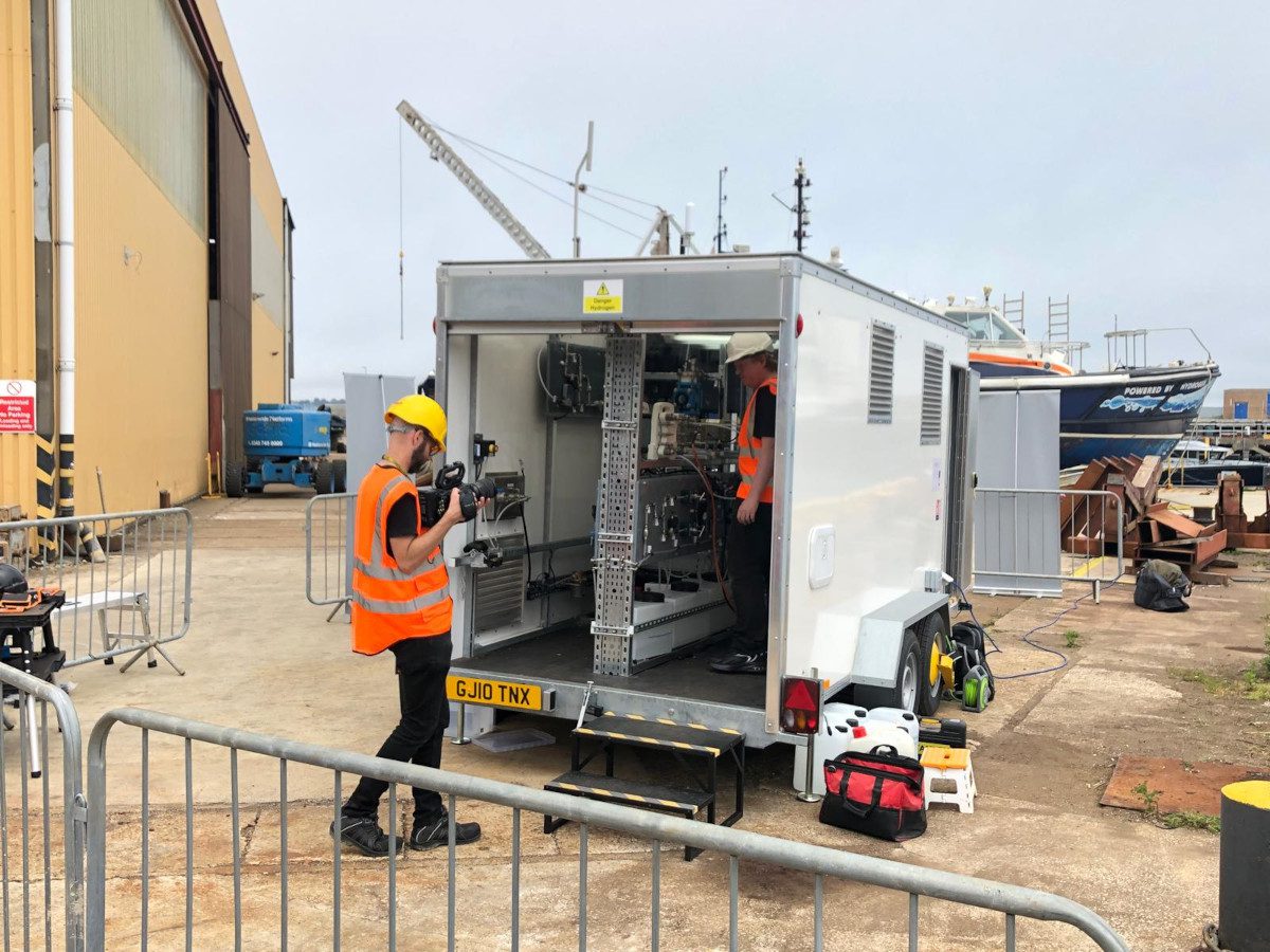 Engineers inspect Latent Drive's SeaStack electrolyser installed in a mobile trailer at Portland Harbour during a demonstration producing hydrogen directly from seawater.