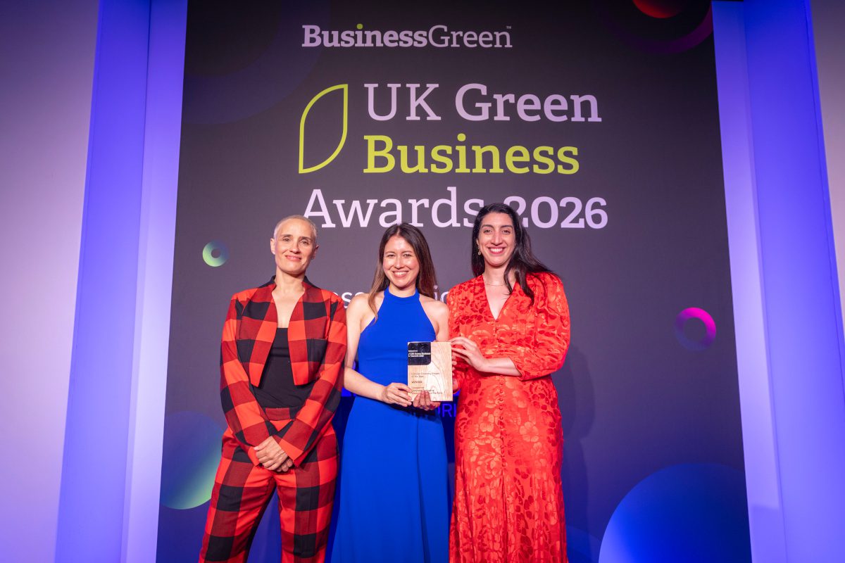Three people pose with an award on stage at the UK Green Business Awards 2026 ceremony beneath a BusinessGreen backdrop