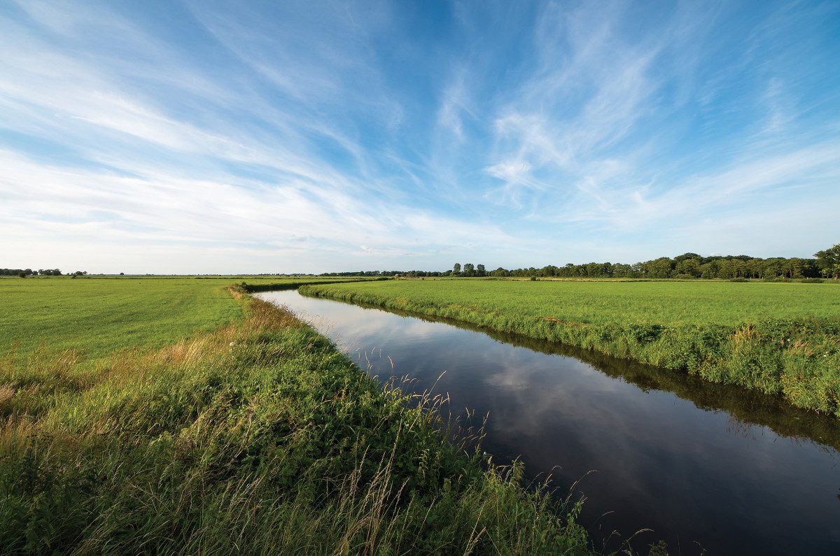 Lowland river flowing through agricultural fields